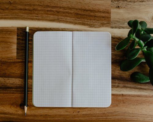 A simple notebook and pen on a wooden table